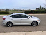 2018 Hyundai Elantra SEL in silver color parked on the street with a scenic background.