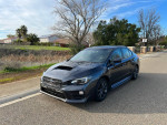 2018 Subaru WRX in grey with black interior, parked on the roadside near greenery.