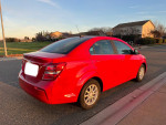 Red 2018 Chevrolet Sonic LT parked on the street, showcasing its sleek design and excellent condition.