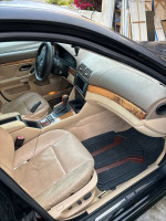 Interior view of a 2001 BMW 530i with beige leather seats and wood accents, requiring engine repair.