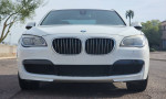 Front view of a 2013 BMW 740i M Sport in white with a sleek design and distinctive grille.