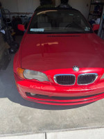 Front view of a 2003 BMW 3 Series 325Ci convertible in red, showcasing its design and condition.