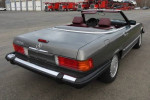 Rear view of a 1989 Mercedes-Benz 560SL in anthracite gray with burgundy interior, pristine condition.
