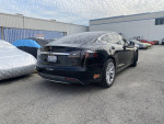 2014 black Tesla Model S parked, features free supercharging, premium interior, and real-time navigation.