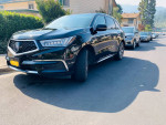 2018 Acura MDX Sport Hybrid in black parked on a street, showcasing its sleek design and luxurious features.