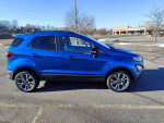 Side view of a blue 2020 EcoSport SES subcompact SUV parked in a lot, showcasing its sporty design and alloy wheels.
