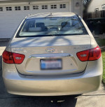 2010 Hyundai Elantra in gold color parked, showcasing its excellent condition and fuel efficiency.