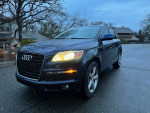 2008 Audi Q7 SUV in dark color, parked in a residential area, showing headlights and sleek design.