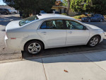 2012 Chevrolet Malibu LS FWD parked on the street, featuring minor scratches and a dented hood.