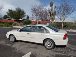 2004 Volvo S80 2.9 FWD in white parked on the street, showcasing sleek design and alloy wheels.