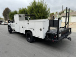 2009 Ford F450 utility bed truck with low miles, ideal for work, parked on the street.