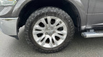 Close-up of a stylish wheel on a 2016 Dodge Ram Laramie Longhorn, showcasing its design and rugged tire.