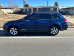 2011 Subaru Outback in blue color, parked on the street, showcasing its automatic features and all-wheel drive.