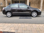 2010 Nissan Sentra SL in black, featuring automatic AC, alloy wheels, and Bluetooth capability.
