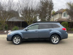 2013 Subaru Outback 2.5i AWD side view, showcasing its sleek design and clean condition with new tires.