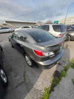 2010 Mazda 3 in gray, parked with minor wear, needs transmission repair, clean title available.