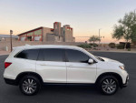Side view of a white 2019 Honda Pilot EX SUV parked, featuring tinted windows and alloy wheels.