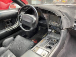 Interior view of a 1990 Chevrolet Corvette with black leather seats and modern stereo system.