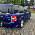 2014 Ford Flex SEL in blue color parked, featuring alloy wheels and tinted windows, suitable for seven passengers.