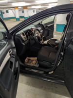 Interior view of a 2011 Toyota Matrix with black cloth seats and manual transmission, showing dashboard and front seats.