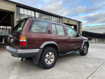 1999 Nissan Pathfinder XE RWD in maroon color parked, showcasing its sporty utility design and clean condition.