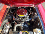 Engine view of a red 1967 Ford Mustang showcasing detailed components and maintenance history.