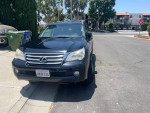 2010 Lexus GX 460 in black parked outside with minor cosmetic wear, featuring seven seats and a tow hitch.