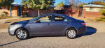 2009 Toyota Camry LE in gray, parked on a street, showcasing its clean exterior and well-maintained condition.