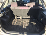 Interior view of the cargo space in a 2003 Mazda 5 with a rubber mat and clean upholstery.