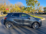 Side view of a 2017 Buick Encore Premium FWD in excellent condition parked on a sunny street.