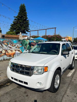 2008 Ford Escape Hybrid in white, parked with vibrant mural background, showcases excellent condition and low mileage