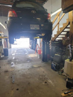 2007 Toyota Yaris hatchback on a lift in a garage during maintenance, showing its rear view.