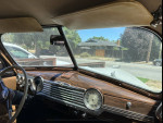 Interior view of a classic 1947 Chevy Fleetmaster coupe with wooden dashboard and gauges.