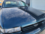 1996 Chevrolet Impala with original paint and gray leather seats, showcasing exceptional condition and low mileage.