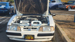 Close-up of a 1989 Ford Mustang LX 5.0 with clean engine bay and California license plate.