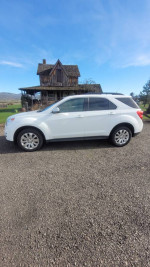 Clean 2011 Chevrolet Equinox SUV in white color parked outdoors with clear blue sky.