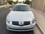 2004 Nissan Maxima with low mileage, silver exterior, parked on the street in good condition.