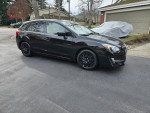 2016 Subaru Impreza Hatchback in black, showcasing its low mileage and sleek design on a driveway.