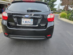 Rear view of a 2016 Subaru Impreza Hatchback AWD with low mileage and rebuilt title, parked on a driveway.