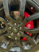 Close-up of a black alloy wheel with red brake caliper on a 2014 Land Rover Range Rover Supercharged