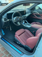 Interior view of a 2024 BMW 4 Series 430i with red leather seats and modern dashboard