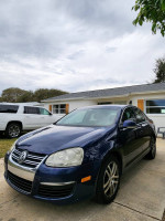 2006 Volkswagen Jetta TDI in Shadow Blue with black leather interior, parked outside a home.