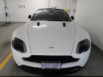 Front view of a pristine 2015 Aston Martin V8 Vantage GT convertible in a parking space.