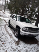 2000 Chevrolet Tahoe parked on a snowy driveway, showcasing its 4-inch lift and chrome wheels.