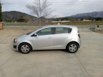 Side view of a silver 2012 Chevrolet Sonic LT parked outdoors with clean exterior and low mileage.