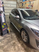 2011 Mazda 3 s Sport Hatchback in a garage, featuring custom black wheels and electric sunroof.