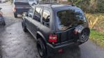 2002 Kia Sportage 4x4 lifted SUV with a textured paint finish and spare tire mounted on the rear