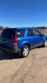 2004 Saturn VUE blue SUV parked on dirt road, showcasing rear and side view in good condition.