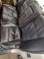 Worn black leather back seat of a 1989 BMW 535i, suitable for restoration or replacement.