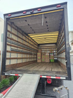 Interior view of a GMC C550 truck showing the ramp and boxes, ready for moving or transportation.